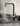 Modern kitchen sink with boiling water running from tap with a white tiled wall