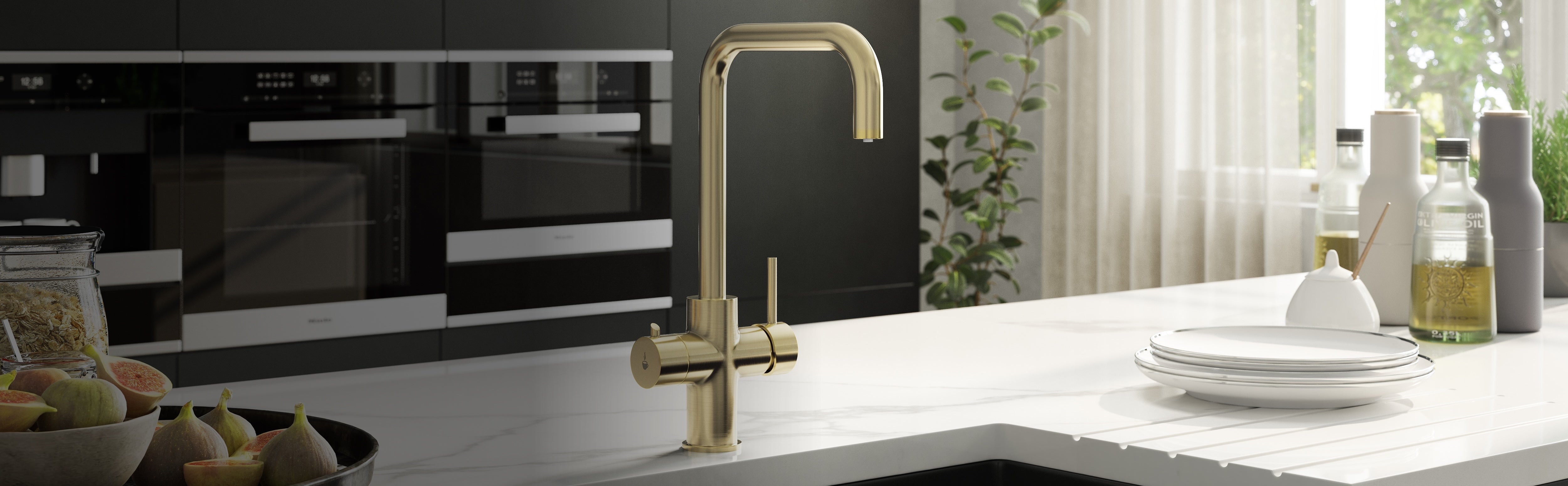 A modern boiling water tap in a brushed brass finish installed on a white marble countertop in a contemporary kitchen setting.