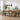 Dining room with wooden table and chairs, plants, and a rug.
