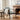 Living room with a brick fireplace, armchair, and potted plant.