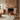 Living room with wooden furniture, a brick fireplace, and a mirror.